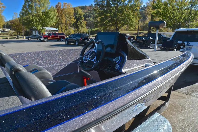 Slide: The Image of 2023 Bullet 21XRS boat interior with steering wheel and dashboard in a parking lot. - 19