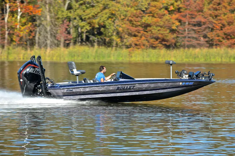 Slide: The Image of 2023 Bullet 21XRS boat speeding on a lake with autumn trees in the background. - 3