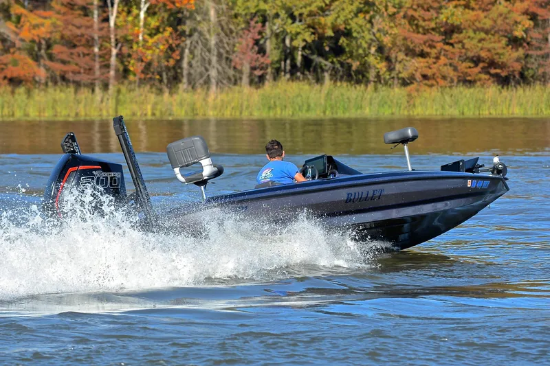 Slide: The Image of 2023 Bullet 21XRS boat speeding on a lake with autumn trees in the background. - 5