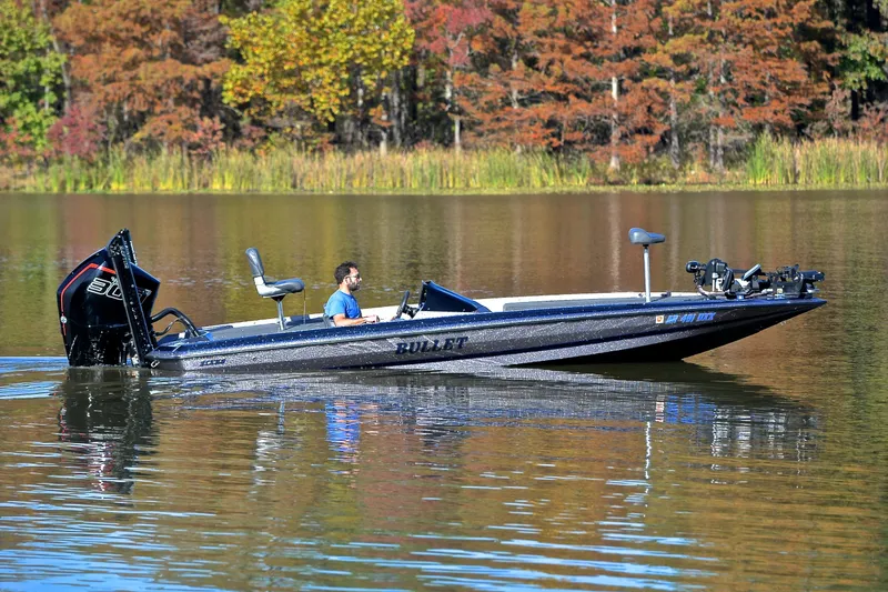 Slide: The Image of 2023 Bullet 21XRS boat on a calm lake with autumn foliage background. - 7