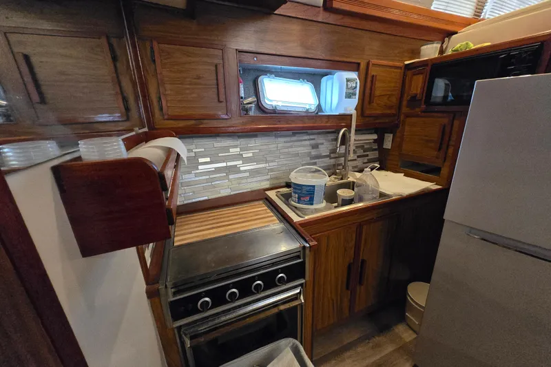 Slide: The Image of 1980 Jersey 40FT Convertible yacht kitchen with wooden cabinets and modern appliances. - 12