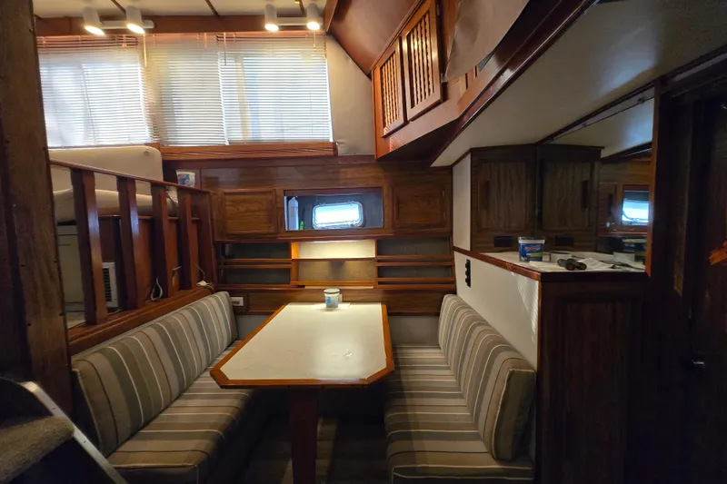 Slide: The Image of Interior of a 1980 Jersey 40FT Convertible yacht with striped seating and wooden accents. - 13