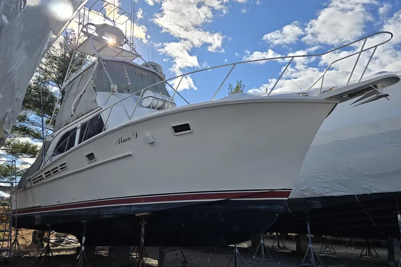 Slide: The Image of 1980 Jersey 40FT Convertible boat on stands, under a blue sky with clouds. - 16