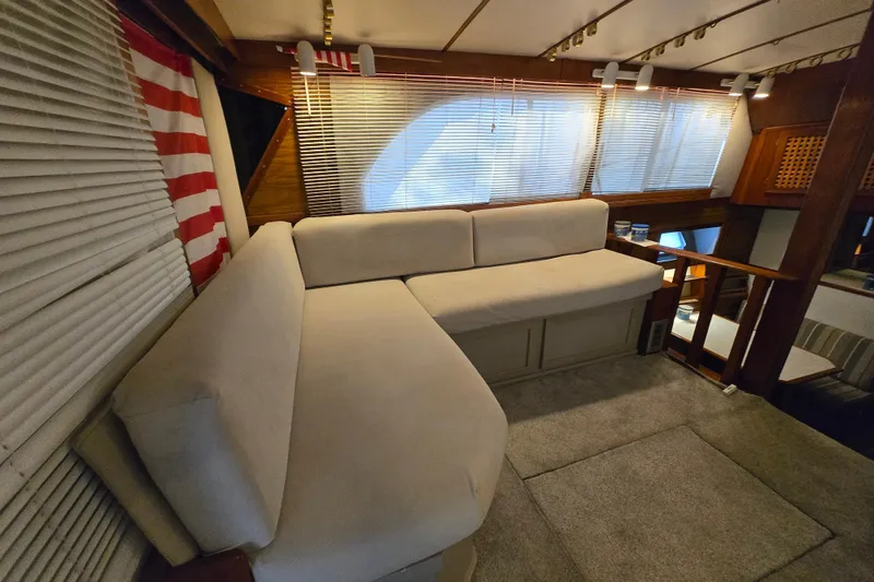 Slide: The Image of Interior of 1980 Jersey 40FT Convertible yacht with cozy seating and striped blinds. - 25