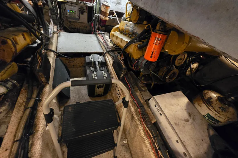 Slide: The Image of Engine room of a 1980 Jersey 40FT Convertible boat, featuring mechanical components and tools. - 28