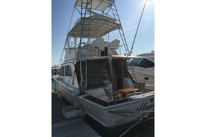 Slide: The Image of 1980 Jersey 40FT Convertible yacht docked at marina, featuring upper deck and seating area. - 33
