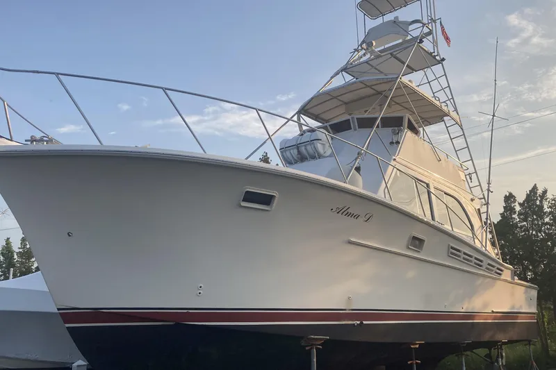 Slide: The Image of 1980 Jersey 40FT Convertible yacht on land, side view, clear sky background. - 36