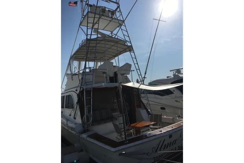 Slide: The Image of 1980 Jersey 40FT Convertible yacht docked, featuring a tall tower and American flag. - 4