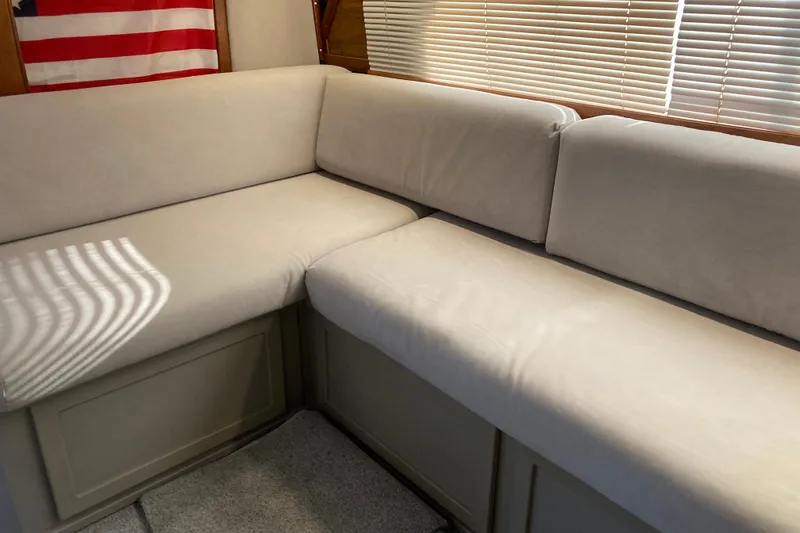 Slide: The Image of Beige sofa in 1980 Jersey 40FT Convertible boat interior with American flag and blinds. - 40