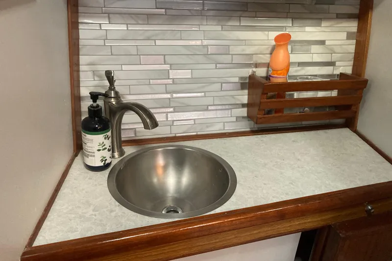 Slide: The Image of Small sink area in a 1980 Jersey 40FT Convertible boat with modern faucet and backsplash. - 49