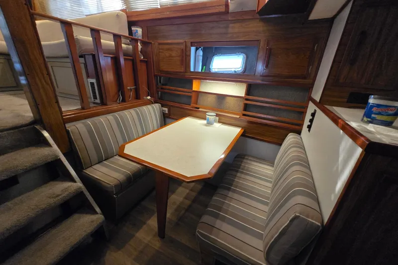 Slide: The Image of Cozy dining area in a 1980 Jersey 40FT Convertible boat with striped seating. - 5