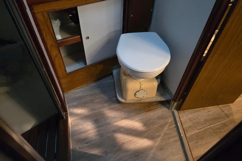 Slide: The Image of 1980 Jersey 40FT Convertible boat bathroom with wooden cabinetry and compact toilet. - 9
