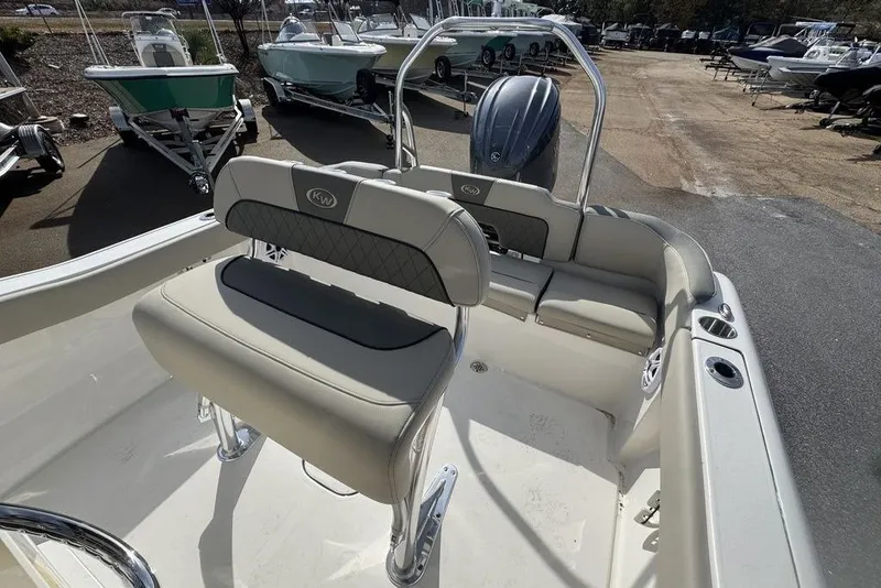 Slide: The Image of 2026 Key West 203 FS boat interior with seating and motor, displayed outdoors. - 10