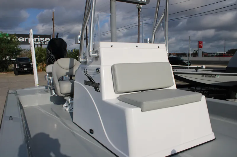 Slide: The Image of 2026 Mamba 24 Cat Elite boat with seating and console, parked outdoors. - 2