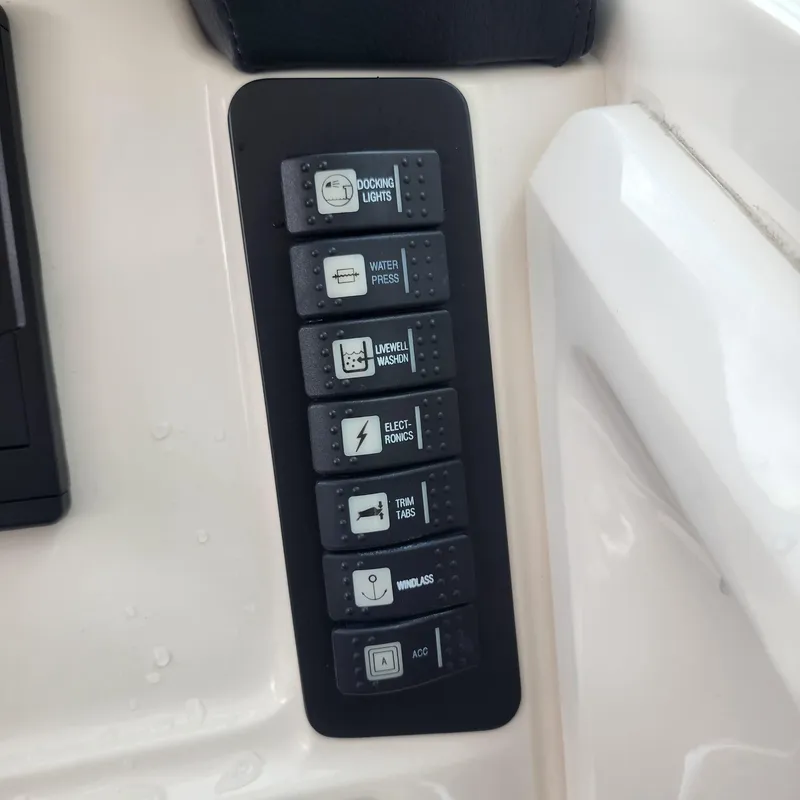 Slide: The Image of Control panel of 2021 Robalo R247 Dual Console boat with labeled switches. - 11
