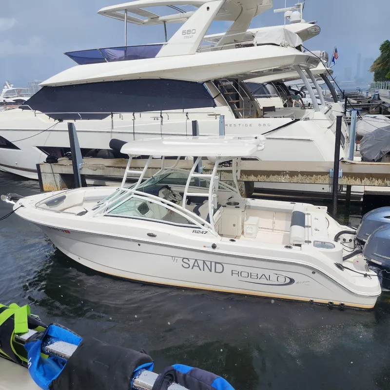 Slide: The Image of 2021 Robalo R247 Dual Console boat docked at marina. - 3