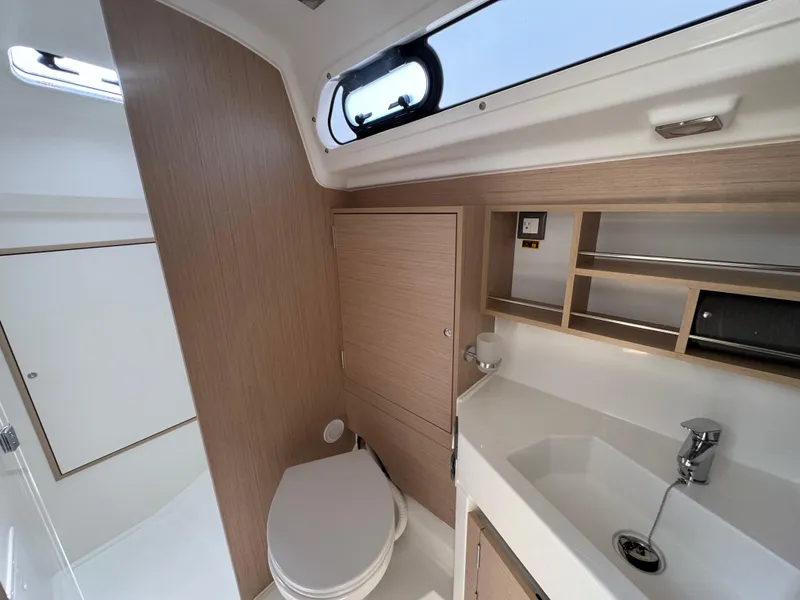 Slide: The Image of 2024 Beneteau Oceanis 34.1 yacht bathroom with modern fixtures and wood accents. - 12