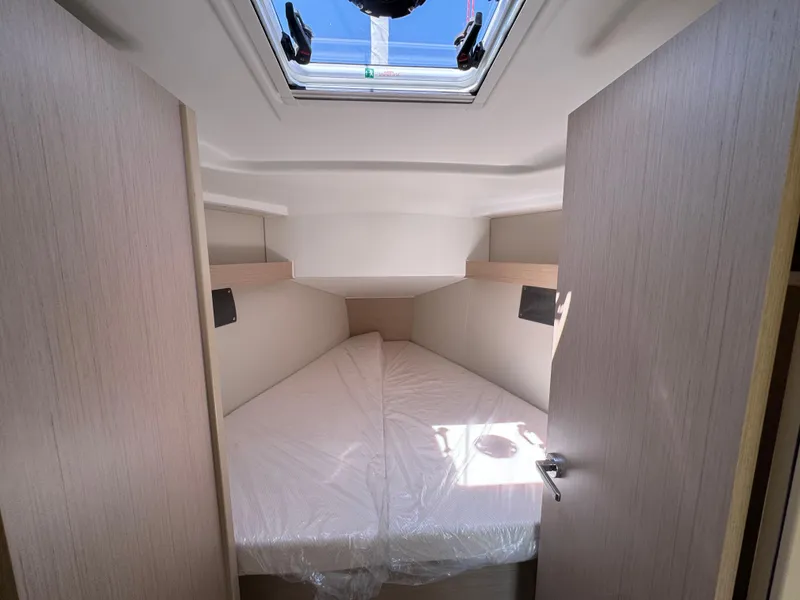 Slide: The Image of 2024 Beneteau Oceanis 34.1 cabin interior with skylight and cozy bed. - 13