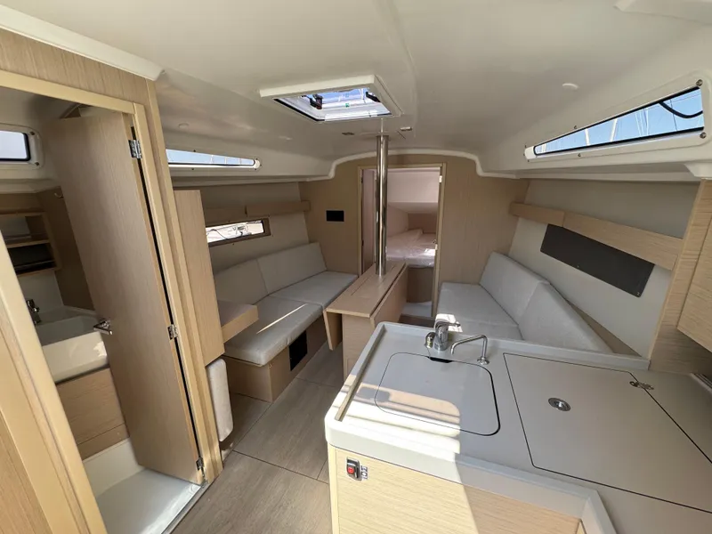 Slide: The Image of 2024 Beneteau Oceanis 34.1 interior with modern kitchen, seating, and natural light. - 15