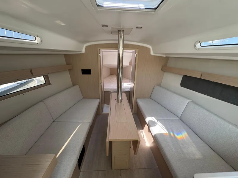 Slide: The Image of 2024 Beneteau Oceanis 34.1 interior with modern seating and natural light. - 16