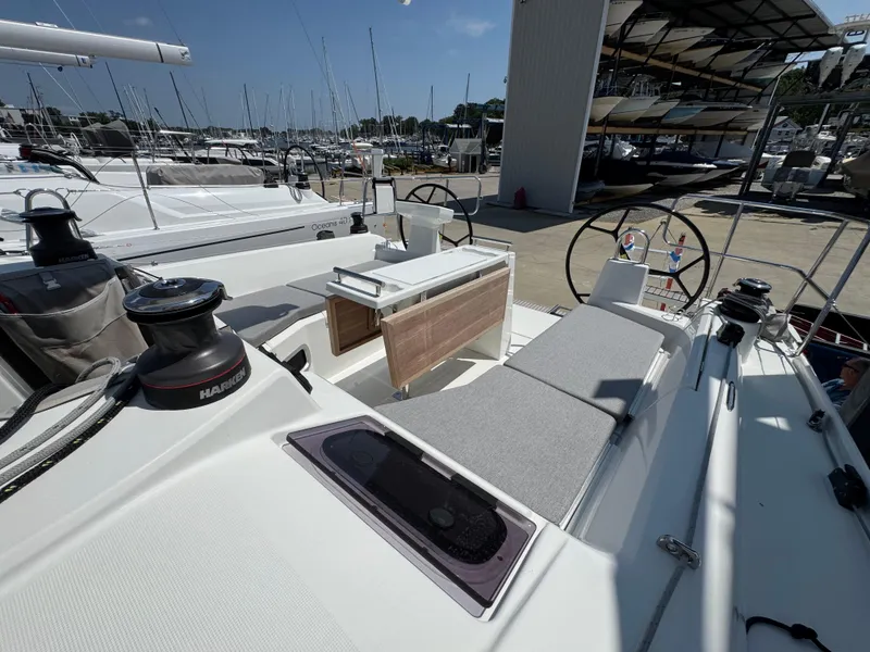 Slide: The Image of 2024 Beneteau Oceanis 34.1 yacht cockpit with seating and steering wheels in a marina setting. - 2