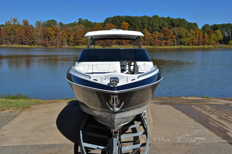 Slide: The Image of 2016 Formula 350 Crossover Bowrider on trailer by scenic lake with autumn trees. - 17