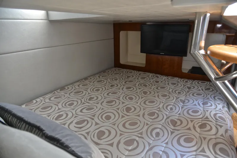 Slide: The Image of 2016 Formula 350 Crossover Bowrider cabin interior with patterned bedding and wall-mounted TV. - 33