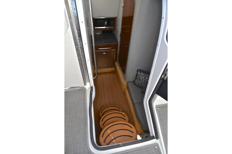 Slide: The Image of Interior view of 2016 Formula 350 Crossover Bowrider, featuring wood flooring and compact kitchenette. - 43