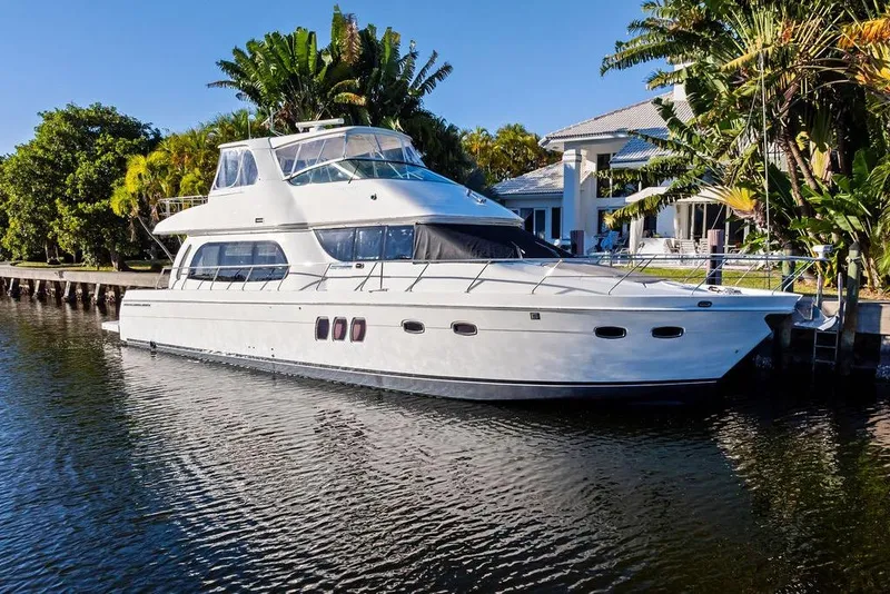 Slide: The Image of 2009 Carver 56 Voyager SE yacht docked by a luxurious waterfront home. - 1