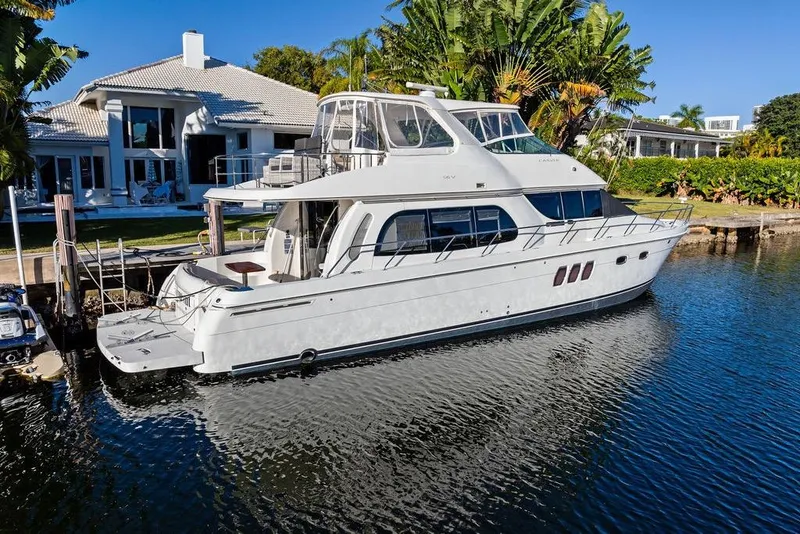 Slide: The Image of 2009 Carver 56 Voyager SE yacht docked by a luxurious waterfront home. - 4