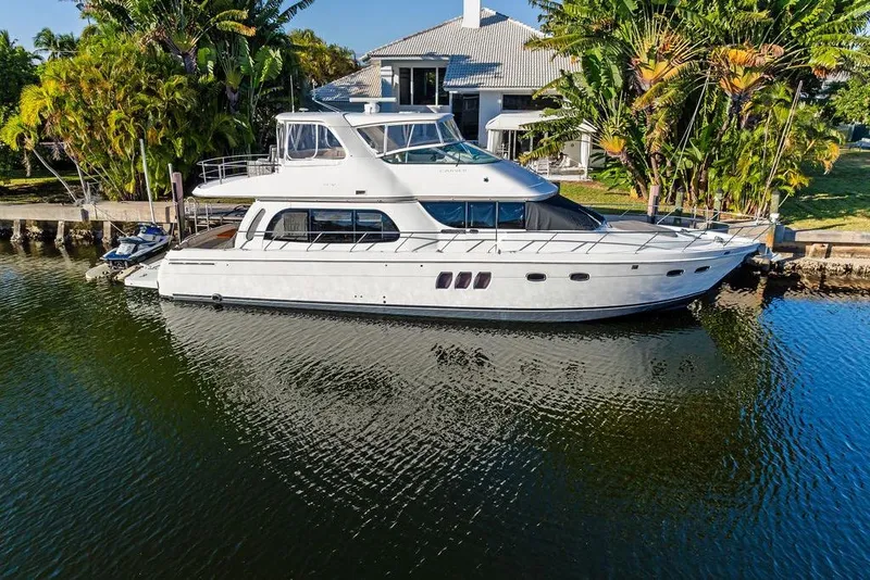 Slide: The Image of 2009 Carver 56 Voyager SE yacht docked by a waterfront home. - 6