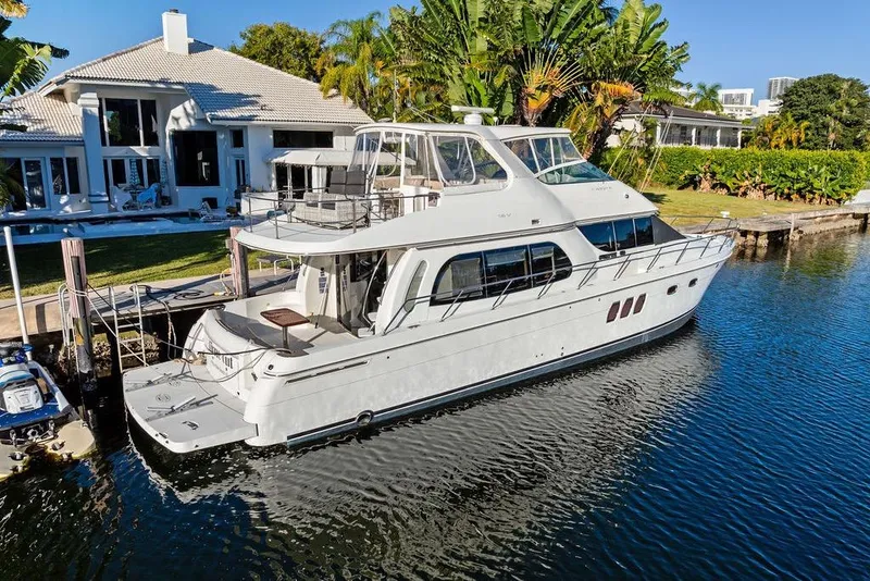 Slide: The Image of 2009 Carver 56 Voyager SE yacht docked by a luxurious waterfront home. - 9