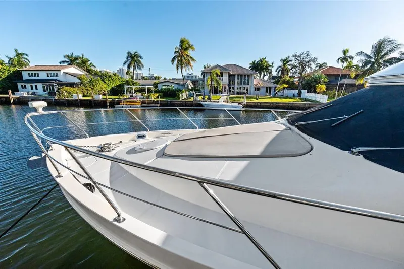 Slide: The Image of 2009 Carver 56 Voyager SE yacht docked by waterfront homes, surrounded by palm trees. - 11