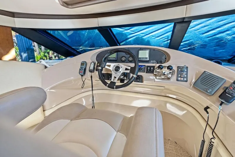 Slide: The Image of 2009 Carver 56 Voyager SE helm with steering wheel and navigation controls. - 21