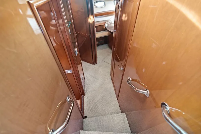 Slide: The Image of Interior of 2009 Carver 56 Voyager SE yacht with wooden finishes and carpeted stairs. - 23