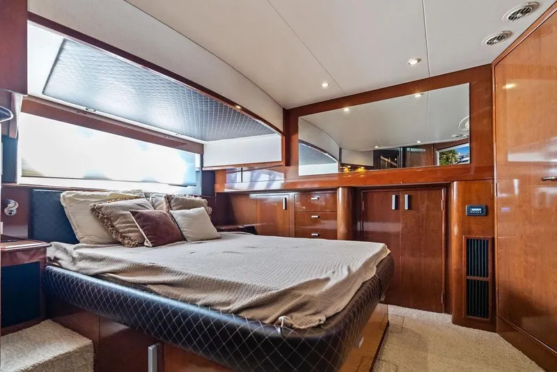 Slide: The Image of Luxurious 2009 Carver 56 Voyager SE yacht bedroom with elegant wood finishes and plush bedding. - 24
