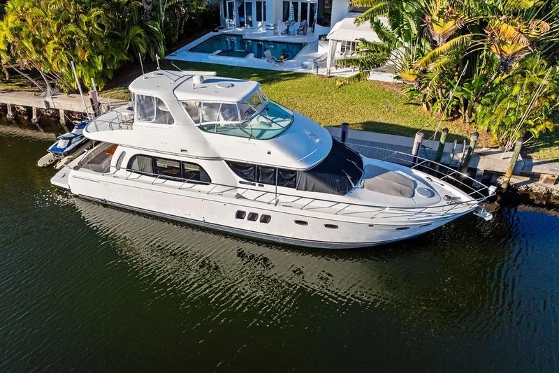 Slide: The Image of 2009 Carver 56 Voyager SE yacht docked by a luxurious waterfront home. - 5