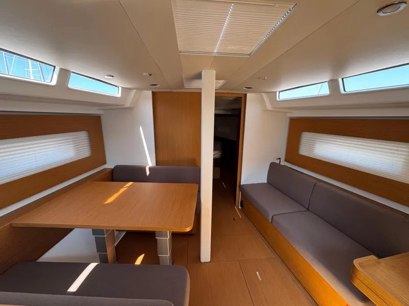 Slide: The Image of 2024 Beneteau First 44 interior with modern wood finish and seating area. - 22