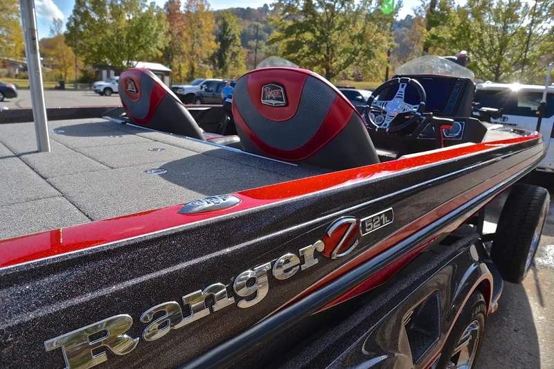 Slide: The Image of 2020 Ranger Z521L boat with red accents, parked outdoors on a sunny day. - 19