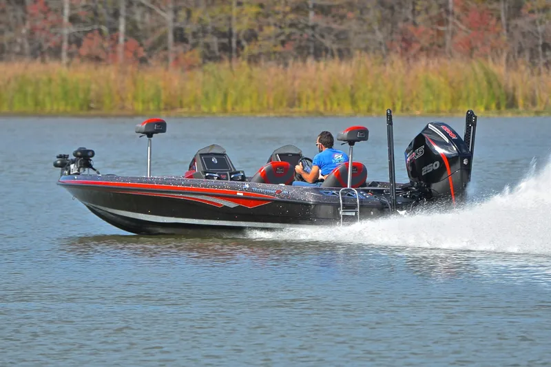 Slide: The Image of 2020 Ranger Z521L boat speeding on a lake with lush greenery in the background. - 4