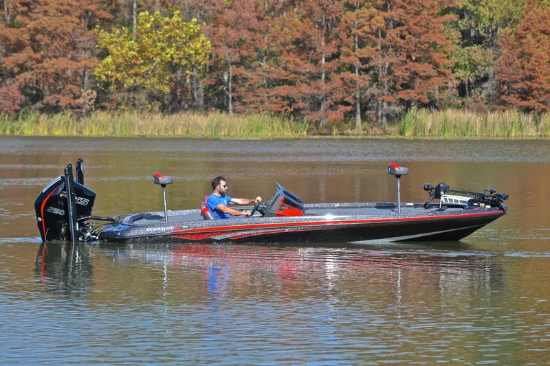 Slide: The Image of 2020 Ranger Z521L boat cruising on a calm lake with autumn foliage backdrop. - 7