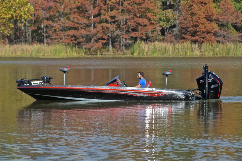 Slide: The Image of 2020 Ranger Z521L boat on a calm lake with autumn trees in the background. - 9