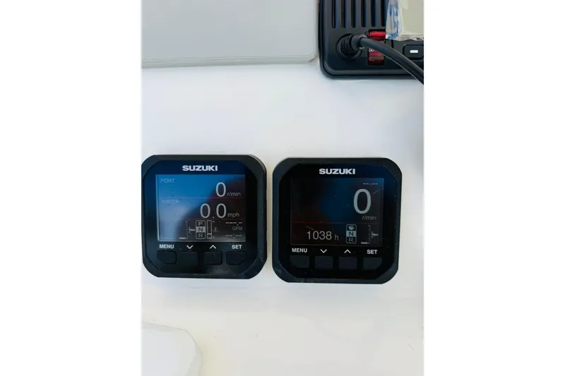 Slide: The Image of Suzuki digital gauges on a 2005 Century 3200 Center Console boat dashboard. - 11