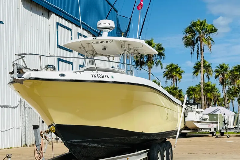 Slide: The Image of 2005 Century 3200 Center Console boat on trailer, palm trees in background. - 3