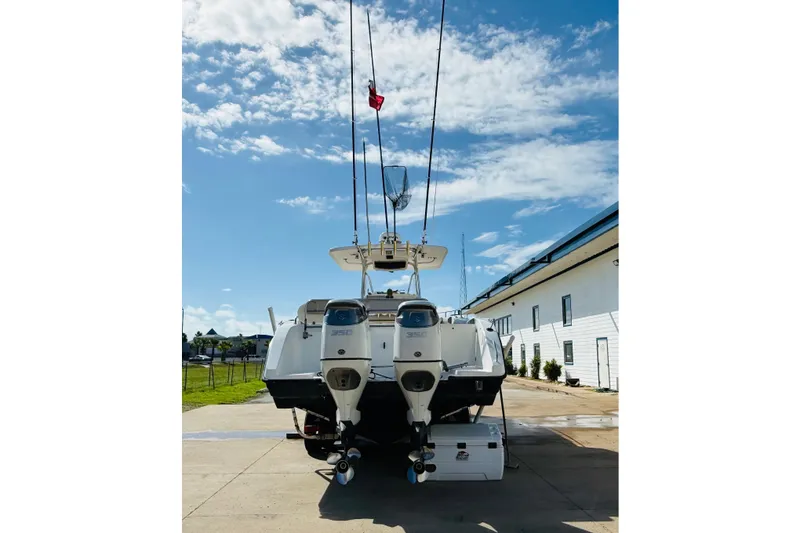 Slide: The Image of 2005 Century 3200 Center Console boat with dual engines, docked under a clear blue sky. - 5