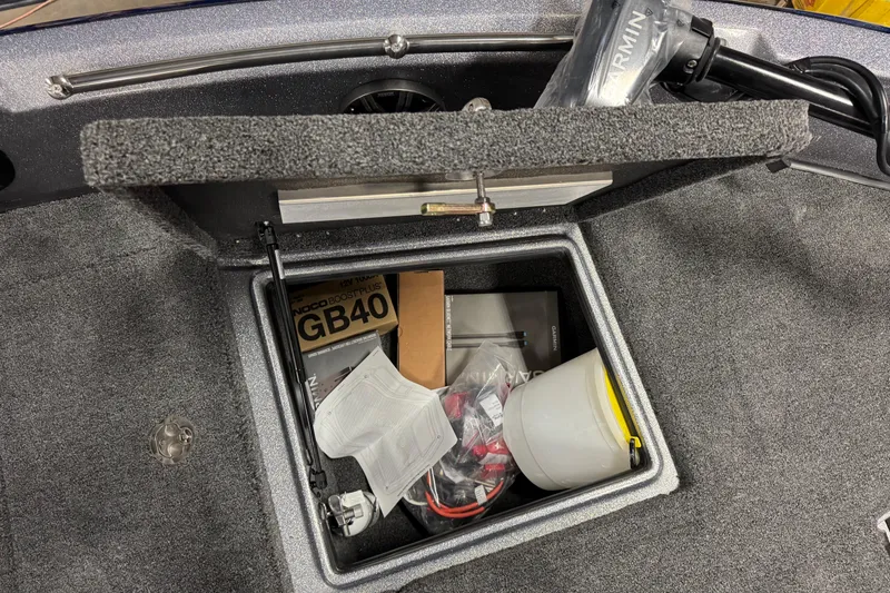 Slide: The Image of Open storage compartment in 2026 Nitro ZV19 Sport Pro boat with various equipment. - 29