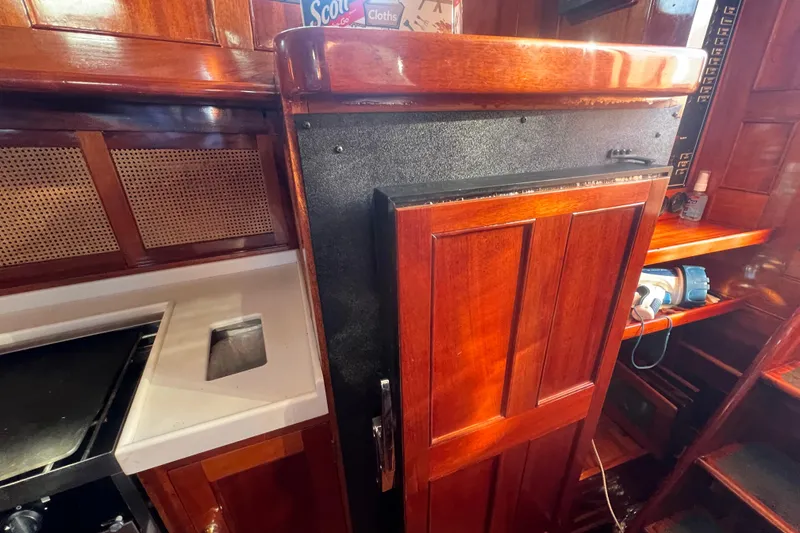 Slide: The Image of 1966 Moody Salar Motorsailer interior with rich wood cabinetry and compact kitchen area. - 10