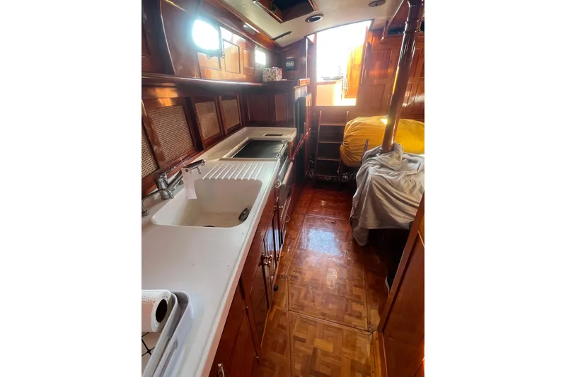 Slide: The Image of 1966 Moody Salar Motorsailer interior with wooden cabinetry and kitchen sink. - 12