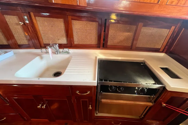 Slide: The Image of 1966 Moody Salar Motorsailer kitchen with wooden cabinets and modern appliances. - 13