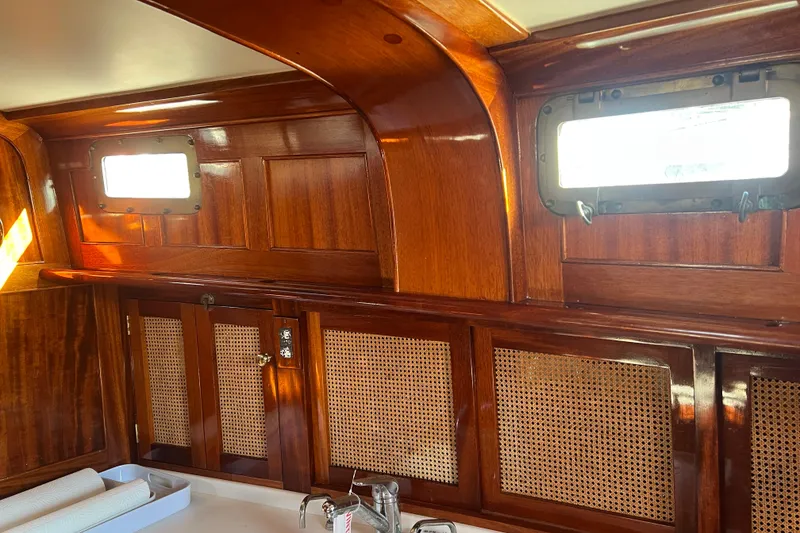 Slide: The Image of Interior of 1966 Moody Salar Motorsailer, featuring polished wood paneling and porthole windows. - 17